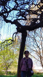 Portrait of young man standing against tree