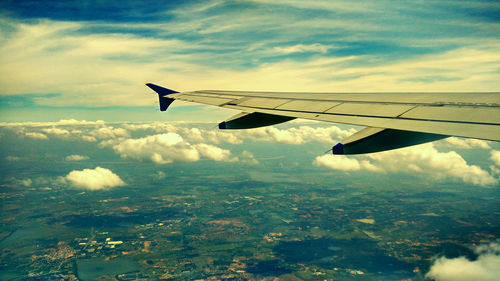 Cropped image of airplane wing over landscape