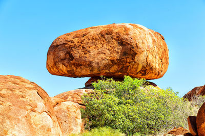 Low angle view of rocks against clear blue sky