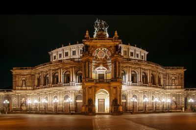 Illuminated semper opera house against sky in city at night