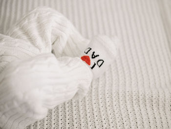 Close-up of hand holding heart shape on bed