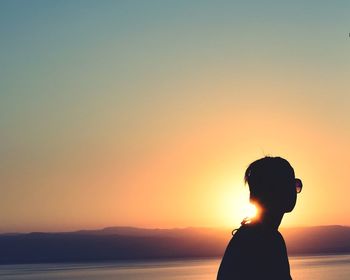 Silhouette woman against sky during sunset