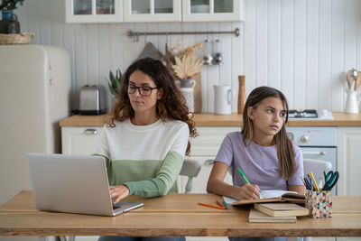 Young woman using laptop at table