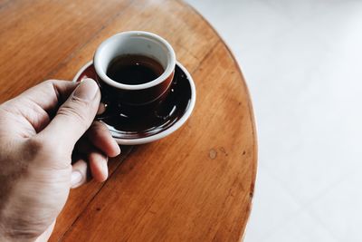 High angle view of hand holding coffee cup