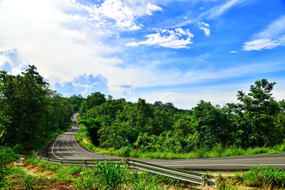 Railroad tracks by road against sky