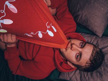 Portrait of young man lying down at home