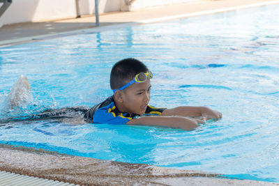 Portrait of boy swimming in pool