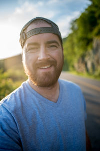 Portrait of smiling mid adult man standing on road