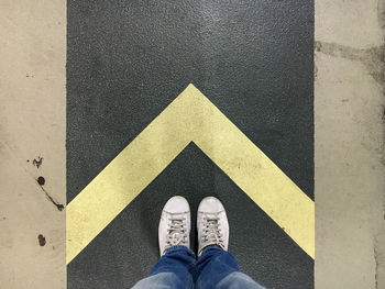 Low section of person standing on road marking