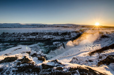 Scenic view of snow covered landscape against sky during sunset