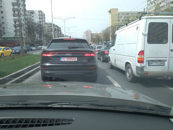 Cars on road in city seen through car windshield