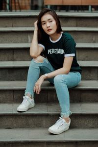 Portrait of young woman sitting on staircase