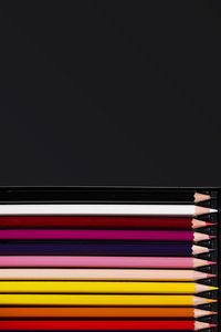 Directly above shot of multi colored pencils against black background