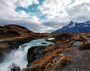 Scenic view of waterfall against sky