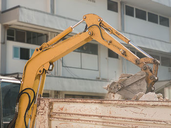 Low angle view of machinery against building