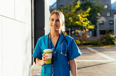 Young woman standing against building