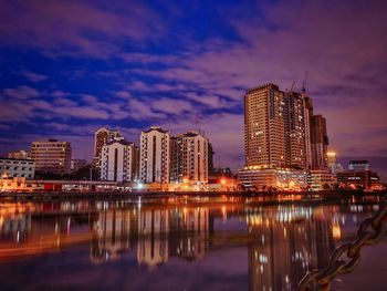 Reflection of illuminated buildings in city at night