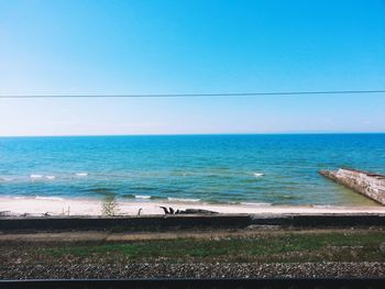 Scenic view of sea against clear blue sky