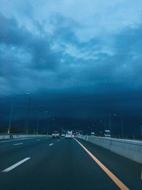 Cars on highway against sky in city