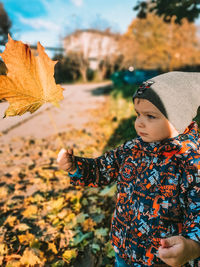 Midsection of woman with autumn leaves