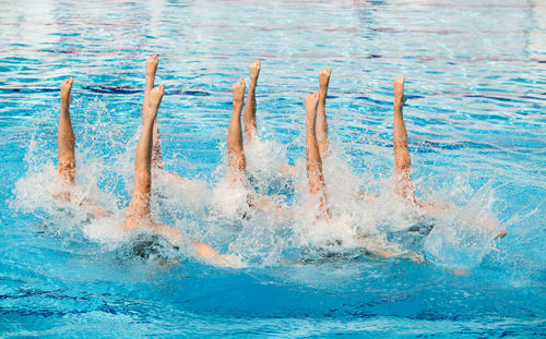 People performing synchronized swimming in pool