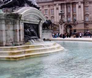 Statue of fountain in front of historical building