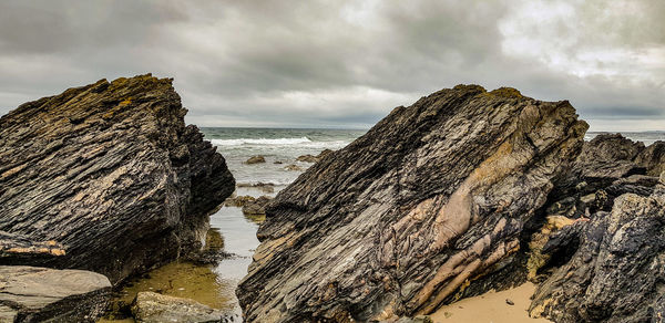 Panoramic view of rocks on beach against sky