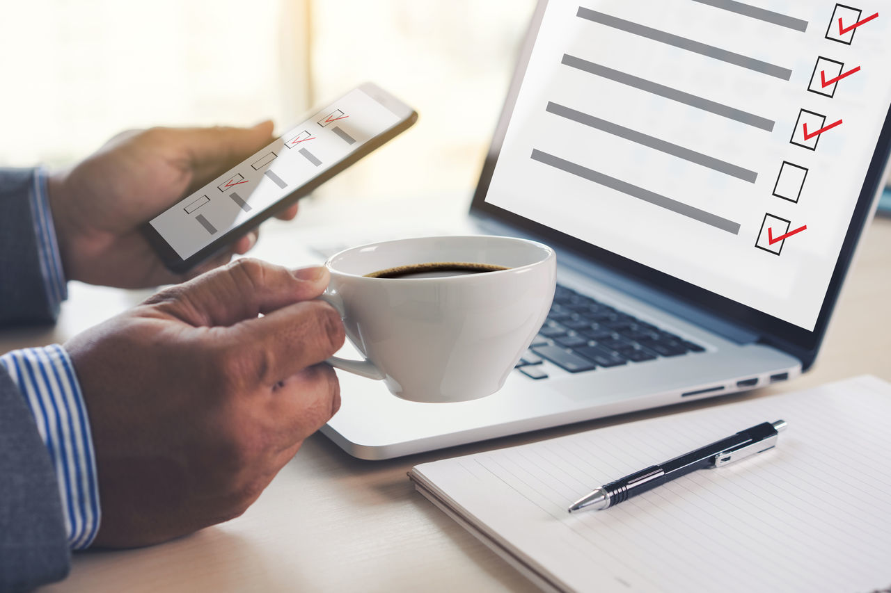 MIDSECTION OF MAN USING LAPTOP ON TABLE