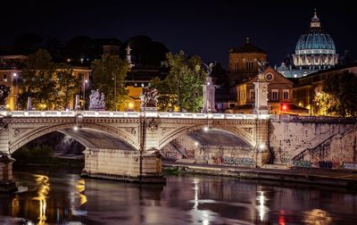 Arch bridge over river at night