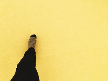 Low section of person standing on yellow floor