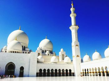 Low angle view of mosque against clear blue sky