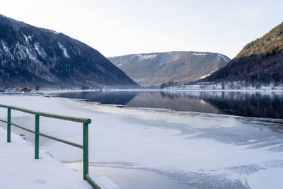 Scenic view of lake by mountains against sky