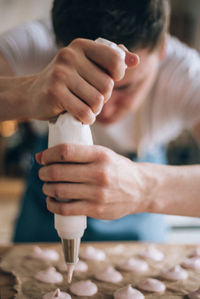 Close-up of man piping cookie dough in kitchen at home