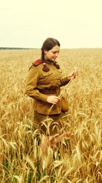 Young woman standing on field against clear sky