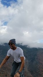 Rear view of man standing on mountain against sky