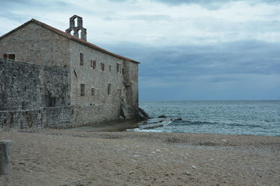 Building by sea against sky