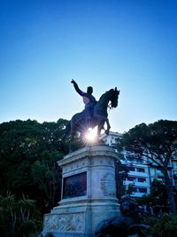 Low angle view of statue against clear blue sky