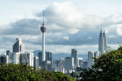 Skyscrapers in city against cloudy sky