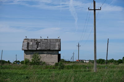 Electricity pylon on field against sky