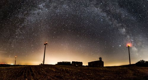 Low angle view of windmill on field against sky at night