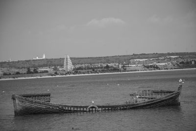 Boats in sea with city in background