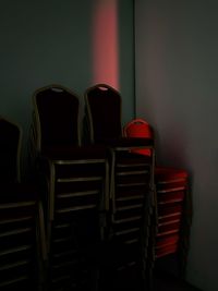 Stack of empty chairs against wall at home