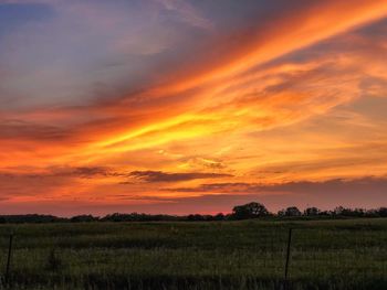 Scenic view of field against romantic sky at sunset