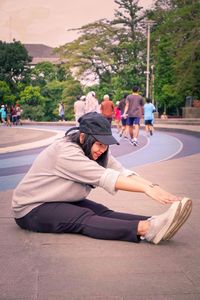 People sitting on road in city