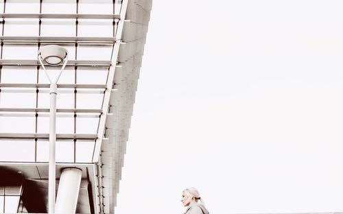 Low angle view of woman against clear sky