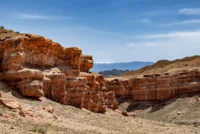 Rock formations on landscape against sky