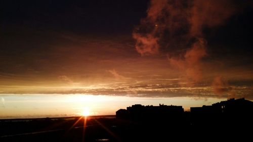 Silhouette of buildings against sky at sunset