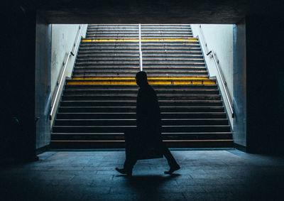 Side view of a silhouette man walking in subway