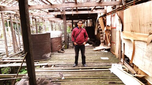 Portrait of young man standing against building