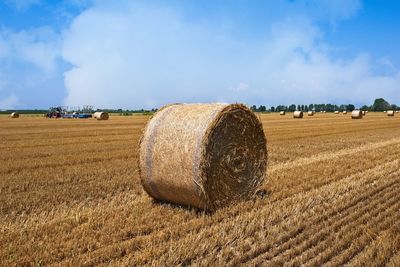 Hay bales on field against sky